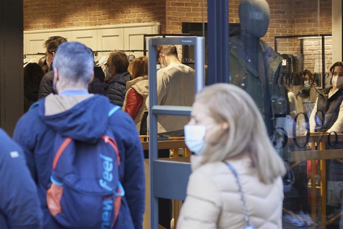 Archivo - Personas haciendo cola para entrar en un comercio donde había aforo completo durante el primer día de las rebajas, a 7 de enero de 2022 en Sevilla (Andalucía, España)