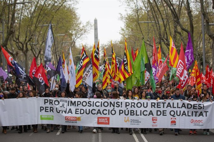 Un grupo de manifestantes sostiene una pancarta y banderas de diferentes sindicatos, cortando Jardinets de Grcia con Avenida Diagonal, como parte de las movilizaciones por la huelga educativa, a 29 de marzo de 2022, en Barcelona