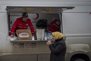Una  mujer recibe una bebida caliente de la Cruz Roja turca, en el paso fronterizo de Porubne, a 5 de marzo de 2022, en el oeste de Ucrania.