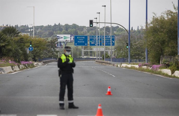 Archivo - Un agente de la Policía Local regula el tráfico en un control en la carreteras de la salida de Sevilla a Huelva, en foto de archivo.