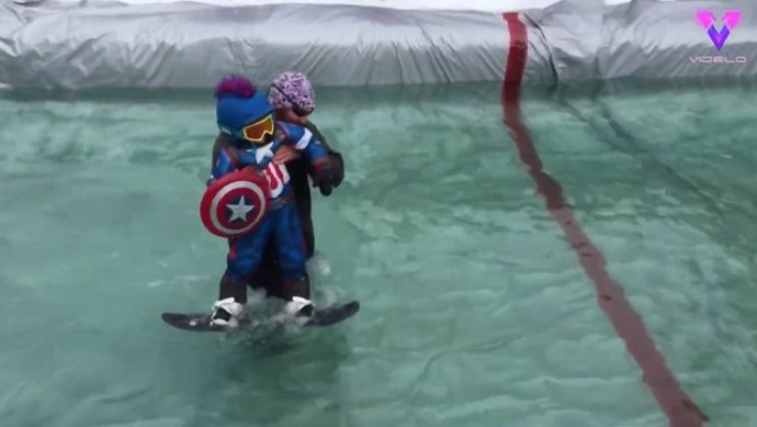 Esquiadores ayudan a un niño a cruzar un estanque