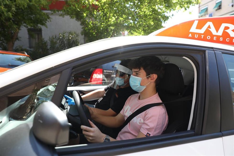 Archivo - El director y profesor de la autoescuela Lara, Fernando Lara, protegido con mascarilla, guantes y pantalla protectora, viaja en coche con el alumno, Miguel L. Quijada, que también va protegido. 