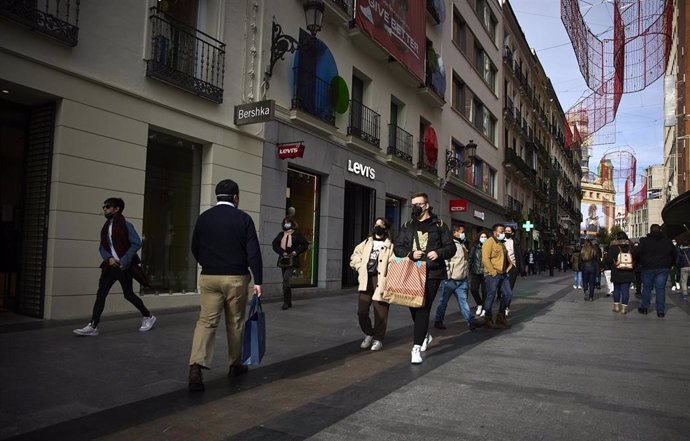 Archivo - Varias personas con bolsas pasean en una calle comercial del centro de Madrid, a 2 de enero de 2022, en Madrid, (España). Comienzan las rebajas de enero que generarán un 14 % más de empleo, sobre todo en logística, respecto a 2021. Aunque las 