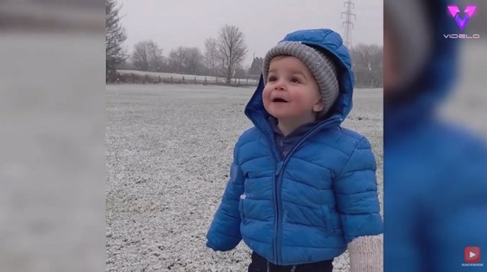 Este niño está emocionado por ver caer la nieve por primera vez