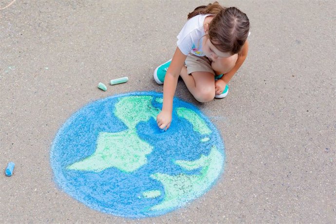 Archivo - Una niña dibuja el planeta Tierra.