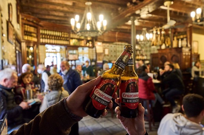 Dos personas brindan con una edición limitada 'El Rinconcillo' en el interior de la centenaria taberna.