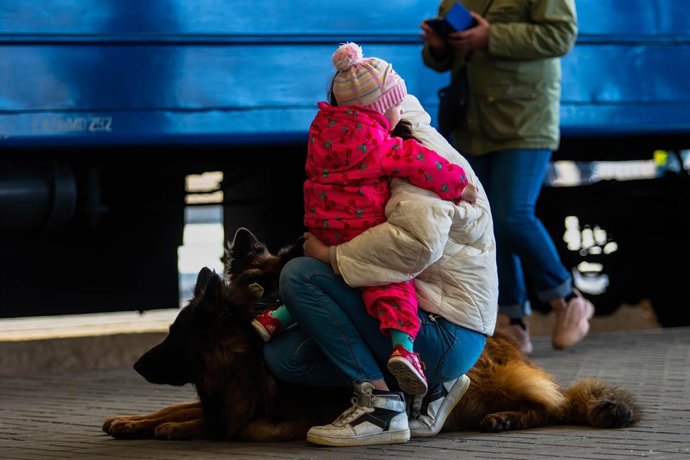 March 24, 2022, Lviv, Lviv Oblast, Ukraine: A woman holds a child and dogs on a train platform after arriving from Mariupol. A train carrying refugees from war torn Mariupol arrived at the Lviv train station. Many will continue their journey from Lviv o
