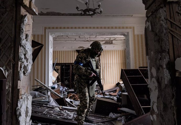 Un soldado ucraniano revisando los destrozos de un bombardeo en un edificio residencial en Járkov