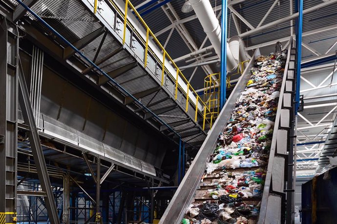 Archivo - Conveyor belt with garbage transports waste inside drum filter or rotating cylindrical sieve with trommel for sorting pieces of garbage into various sizes fractions, at waste recycling plant.