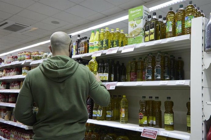 Una persona comprando aceite en un supermercado  
