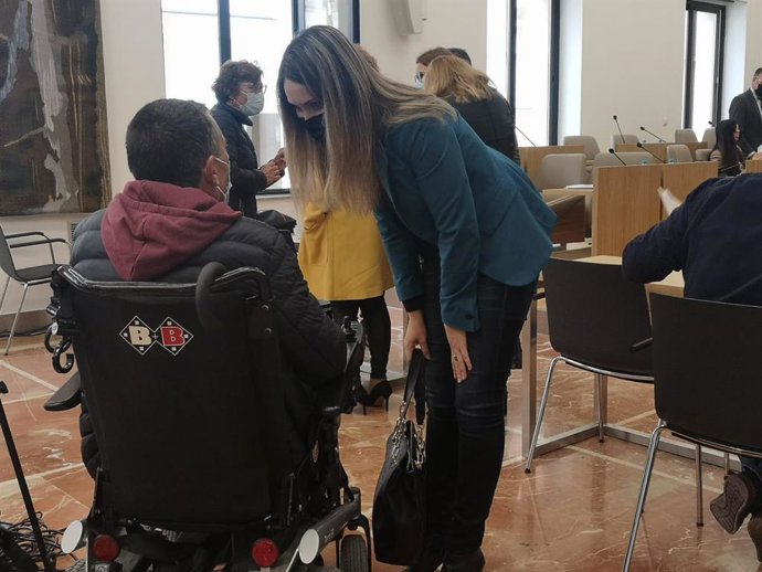 La diputada provincial de Cs, María Ponce,  saluda a uno de los enfermos de ELA que han acudido al pleno de la Diputación.