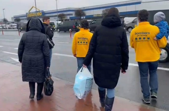 Imagen de dos Bombers per Ucrana y varios refugiados