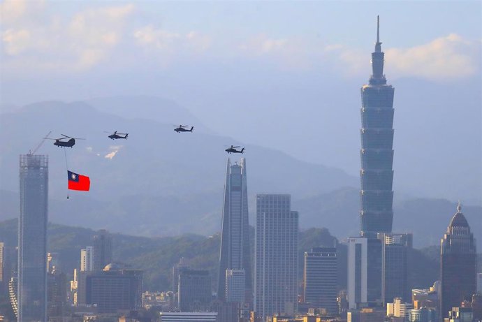 Archivo - 05 October 2021, Taiwan, New Taipei City: A military helicopter carrying a tremendous Taiwan flag conducts a flyby rehearsal with other helicopters ahead of the Double-tenth National Day celebration, near Taipei 101, amid China's growing milit