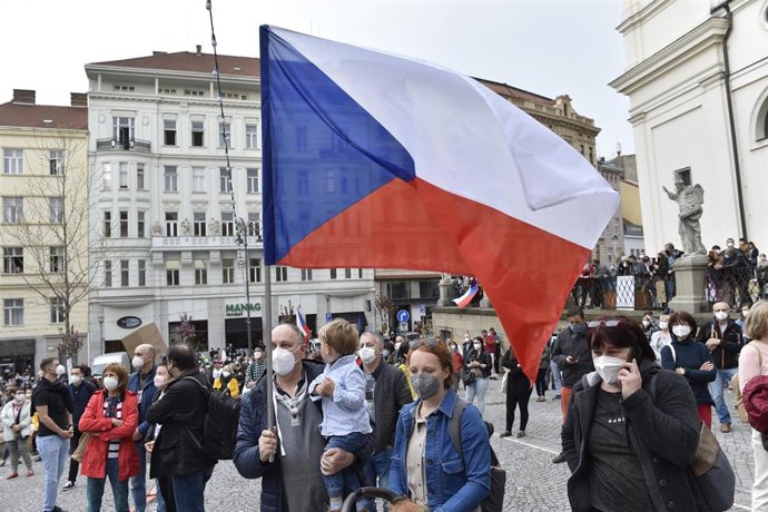 Archivo - Un hombre sostiene una bandera de República Checa en Praga, la capital. 
