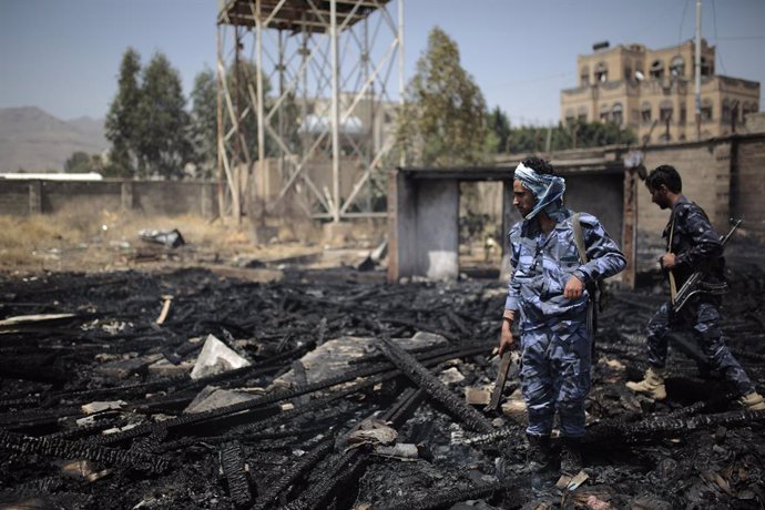 26 March 2022, Yemen, Sanaa: Yemeni policemen inspect a site that was damaged by an air strike allegedly carried out by the Saudi-led coalition, a day after the Houthis rebels targeted Saudi Arabia's oil facilities with rocket attacks. Photo: Hani Al-An