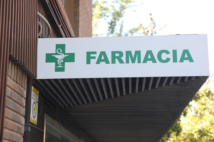 Archivo - Letrero verde de una farmacia en una calle de Madrid.