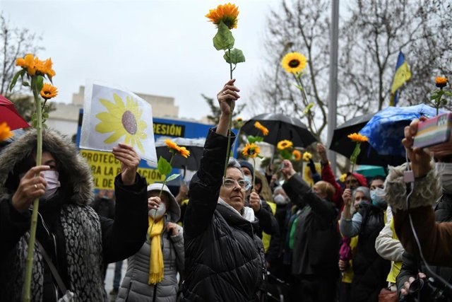 Varias personas sostienen girasoles, la flor nacional ucraniana, durante una manifestación en apoyo a Ucrania.