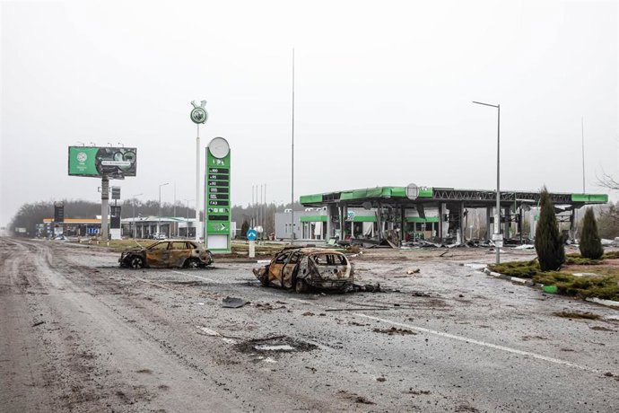 Restos de coches calcinados junta a una gasolinera en Bucha, Ucrania