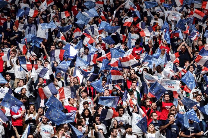 02 April 2022, France, Nanterre: Supporters of French President Macron, who is running for re-election with the centrist La Republique en Marche (LREM) party, wave flags during a campaign rally at La Defense Arena. Photo: Ludovic Marin/AFP/dpa