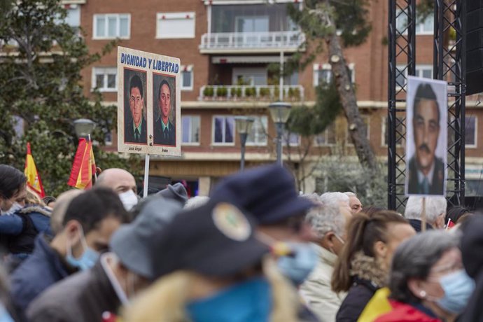 Varias personas con pancartas en la manifestación de la AVT en contra del "Gobierno traidor",  celebrada en Colón (Madrid) el 26 de marzo