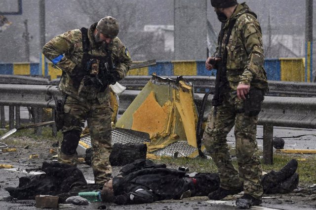 Soldados ucranianos miran un cuerpo tras la retirada rusa de Bucha. 