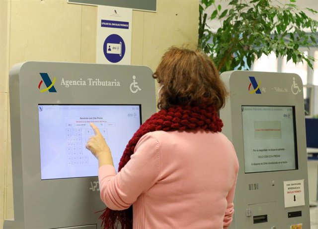 Una mujer recoge su turno en una oficina de la Agencia Tributaria un día antes de que dé comienzo el inicio por internet de la Campaña de la Renta 2021, en una oficina de la Agencia Tributaria, a 5 de abril de 2022, en Madrid (España).
