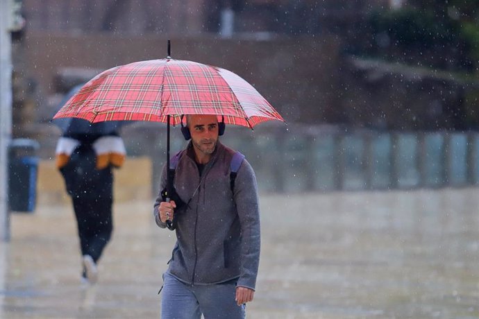 Un hombre con paraguas bajo la lluvia