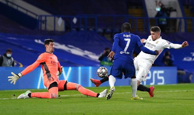 Archivo - El jugador del Chelsea N'Golo Kante (centro) remata ante el portero del Real Madrid Thibaut Courtois, pero el disparo lo bloquea el centrocampista Federico Valverde en semifinales de la Champions 2020-2021.