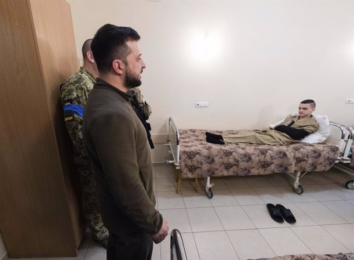 03 April 2022, Ukraine, Kiev: Ukrainian President Volodymyr Zelensky (L)visits a wounded soldier at the Main Military Medical Center in Kiev. The President presented medals to eight soldiers of the border guard wounded in battles for Kharkiv, Chernihiv