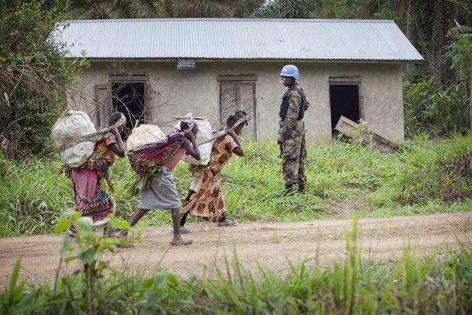 Archivo - Un 'casco azul' de la MONUSCO junto a unas mujeres en Beni, en el este de RDC