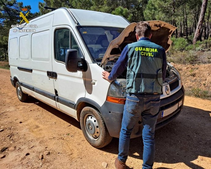 Agente de la Guardia Civil de Almería, con la furgoneta recuperada en la operación por la que han detenido a dos personas
