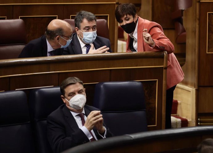 (I-D) El diputado del PNV, Mikel Legarda; el portavoz del PNV en el Congreso de los Diputados, Aitor Esteban; y la ministra portavoz, Isabel Rodríguez, conversan en una sesión plenaria en los asientos del hemiciclo al lado del ministro de Agricultura, L