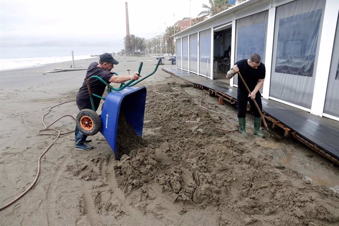 Dos hosteleros recogen los desperfectos causados por el temporal en las últimas horas, que han dejado los chiringuitos anegados por las inundaciones, en la imagen la playa de Huelín a 5 de abril de 2022 en Málaga, Andalucía.