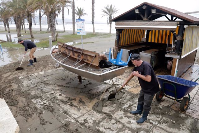 Dos hosteleros recogen los desperfectos causados por el temporal en las últimas horas, que han dejado los chiringuitos anegados por las inundaciones, en la imagen la playa de Huelín a 5 de abril de 2022 en Málaga, Andalucía.