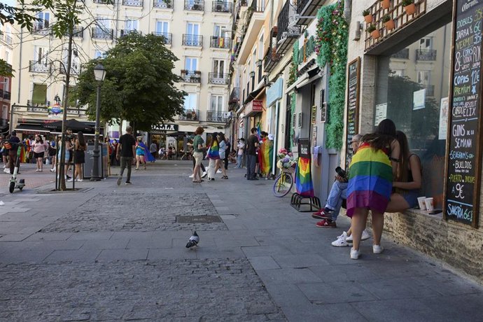 Archivo - Varias personas con la bandera LGTBI en el barrio de Chueca durante la celebración del Día Internacional del Orgullo LGTBI.