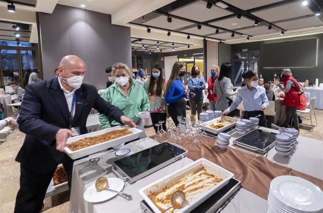 Varios empleados sirven comida en un comedor en el Hotel Novotel donde se encuentran niños refugiados ucranianos