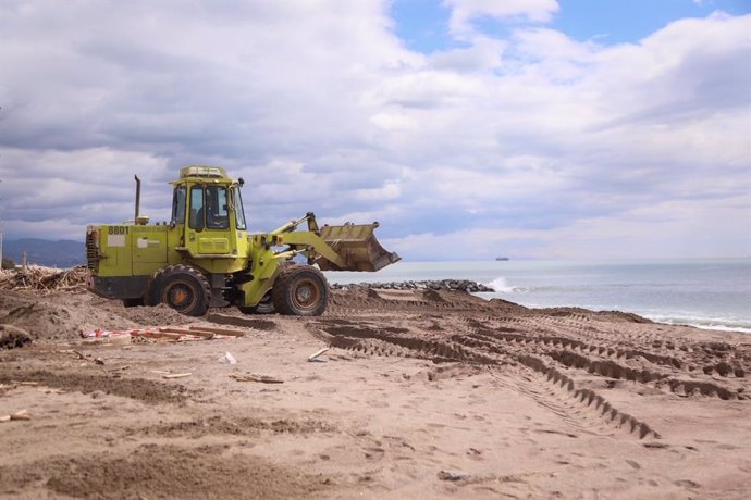 Una excavadora del Ayuntamiento de Málaga trabaja en la recuperación de las playas de la ciudad tras el temporal de principios de abril de 2022