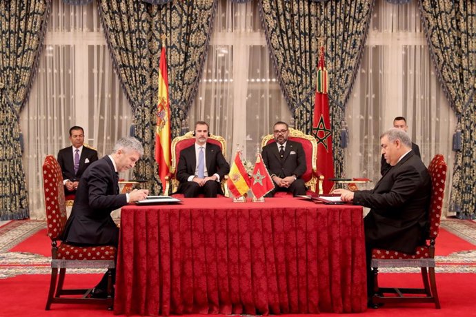 Archivo - (I-D al fondo) El Rey Felipe VI y el Rey Mohamed VI, y en la mesa,el ministro del Interior, Fernando Grande-Marlaska (1i), durante la firma del Convenio bilateral en materia de Lucha contra la Delincuencia entre los Ministerios de Interior de 