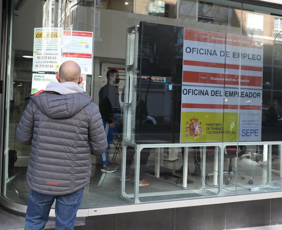 Archivo - Un hombre observa la cristalera de una Oficina de Empleo, en una imagen de archivo.