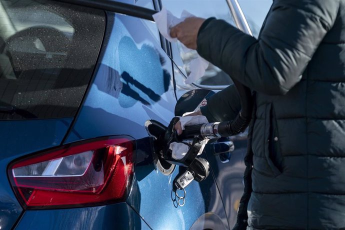 Una persona pone gasolina en una gasolinera.