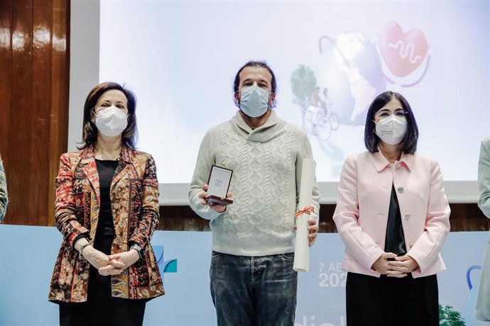 El fotoperiodista Jesús Hellín, posa con la ministra de Defensa, Margarita Robles (i), y la ministra de Sanidad, Carolina Darias (d), tras recibir un premio por la gestión de las coberturas de pandemia, en el Ministerio de Sanidad, a 7 de abril de 2022,