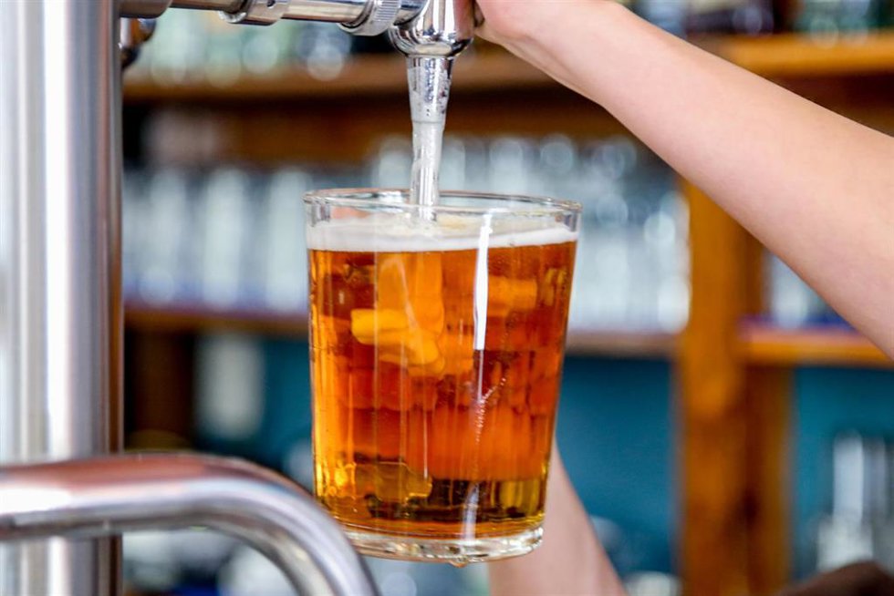 Un camarero tira una cerveza en un bar en una foto de archivo.