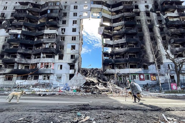 Una mujer camina junto a un edificio arrasado por los bombardeos rusos en la ciudad ucraniana de  Borodyanka