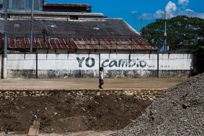 Niño salvadoreño frente a una prisión
