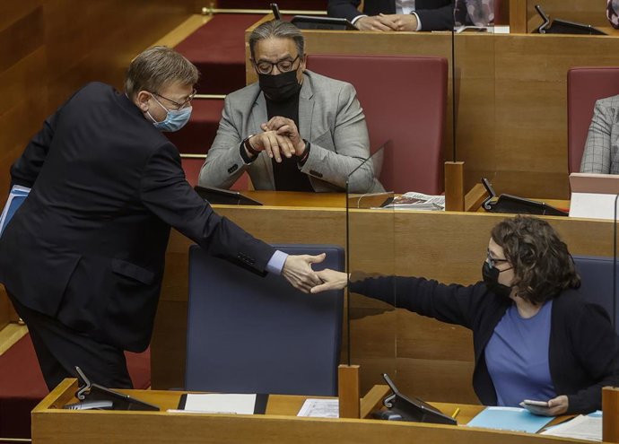 El president de la Generalitat, Ximo Puig, y la vicepresidenta, Mónica Oltra, se dan la mano durante una sesión de control de Les Corts