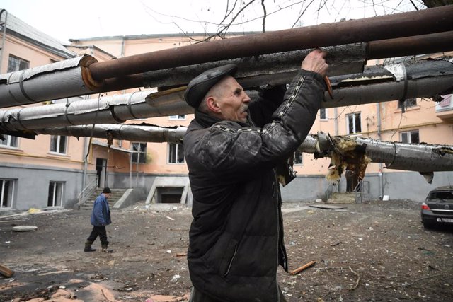 Archivo - Un hombre repara las tuberías dañadas durante un bombardeo en la autoproclamada República Popular de Donetsk. 