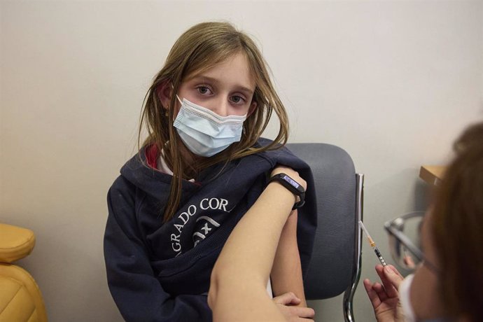 Archivo - Una niña recibe una dosis de la vacuna contra el Covid-19, en el Hospital La Paz