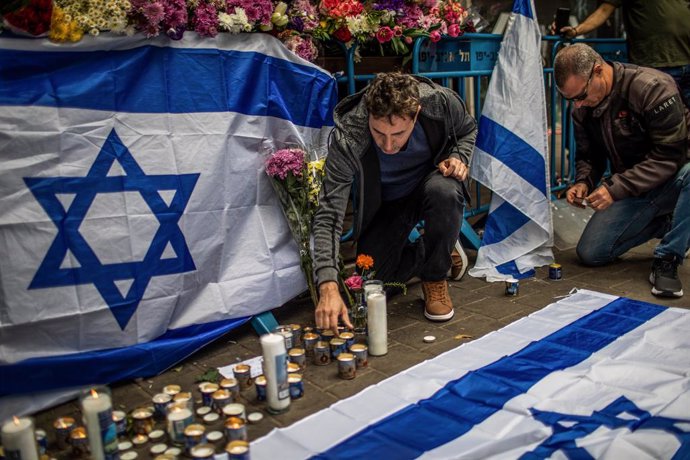 08 April 2022, Israel, Tel Aviv: Mourners light candles while paying tribute to terror victims at the location of an attack in central Tel Aviv. Israel is in a state of high alert following a wave of terror attacks that claimed the lives of 13 people ov