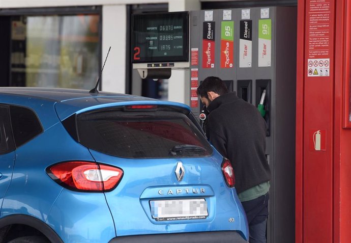 Un hombre echa gasolina a su vehículo en una estación de servicio