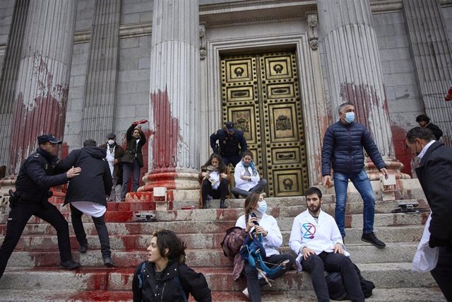 Varios manifestantes son desalojados por la Policía, en una acción de desobediencia para pedir más ambición en la lucha contra el calentamiento, en La Puerta del Congreso de los Diputados, a 6 de abril de 2022, en Madrid (España). Esta protesta se ha suma